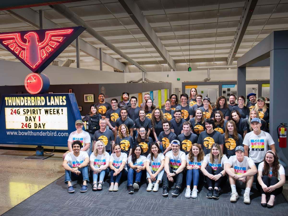 Group picture of 24G interns next to Thunderbird Lanes sign, which reads '24G Spirit Week! Day 1: 24G Day